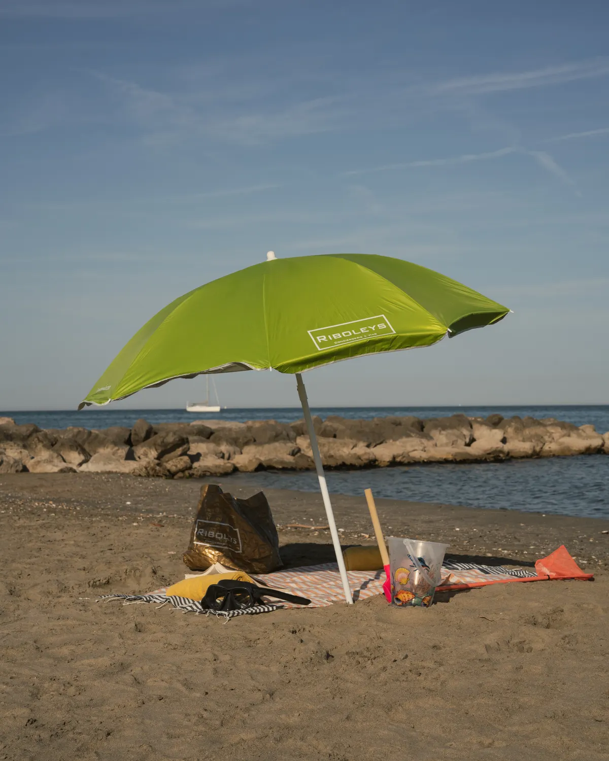 Parasol Riboleys sur la plage de Vias, serviette et jeux de plage au bord de la mer